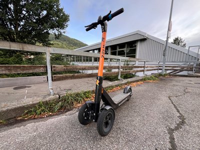 Orangefarbener E-Scooter auf Parkplatz